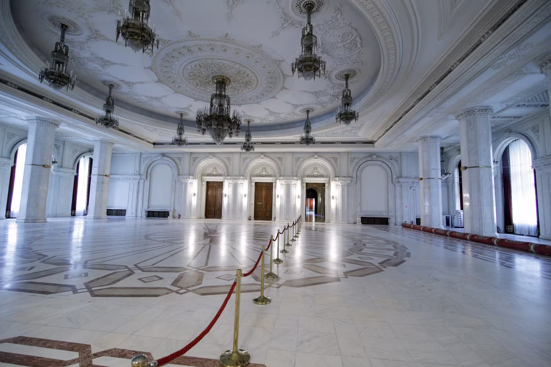 Explore the grand marble hall of Bucharest's Palace of Parliament on a Spanish guided tour.