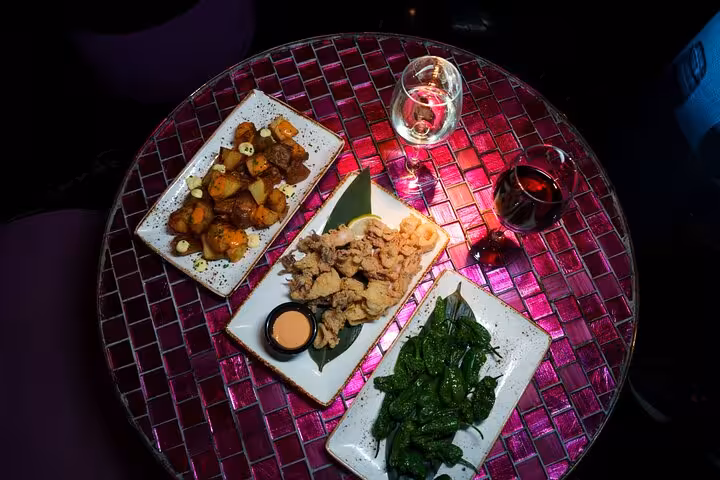 A vibrant spread of traditional Spanish tapas with drinks set on a decorative table in Barcelona.