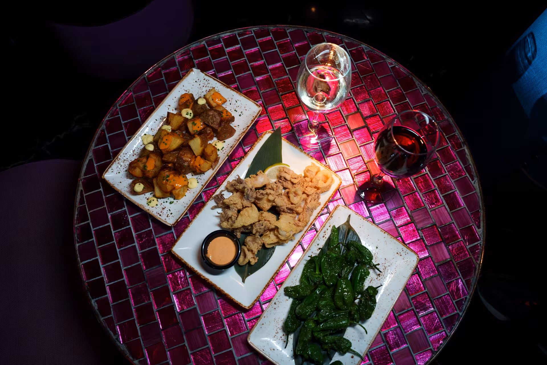 Assorted Spanish tapas with wine on a vibrant mosaic table, enhancing the private flamenco show experience.