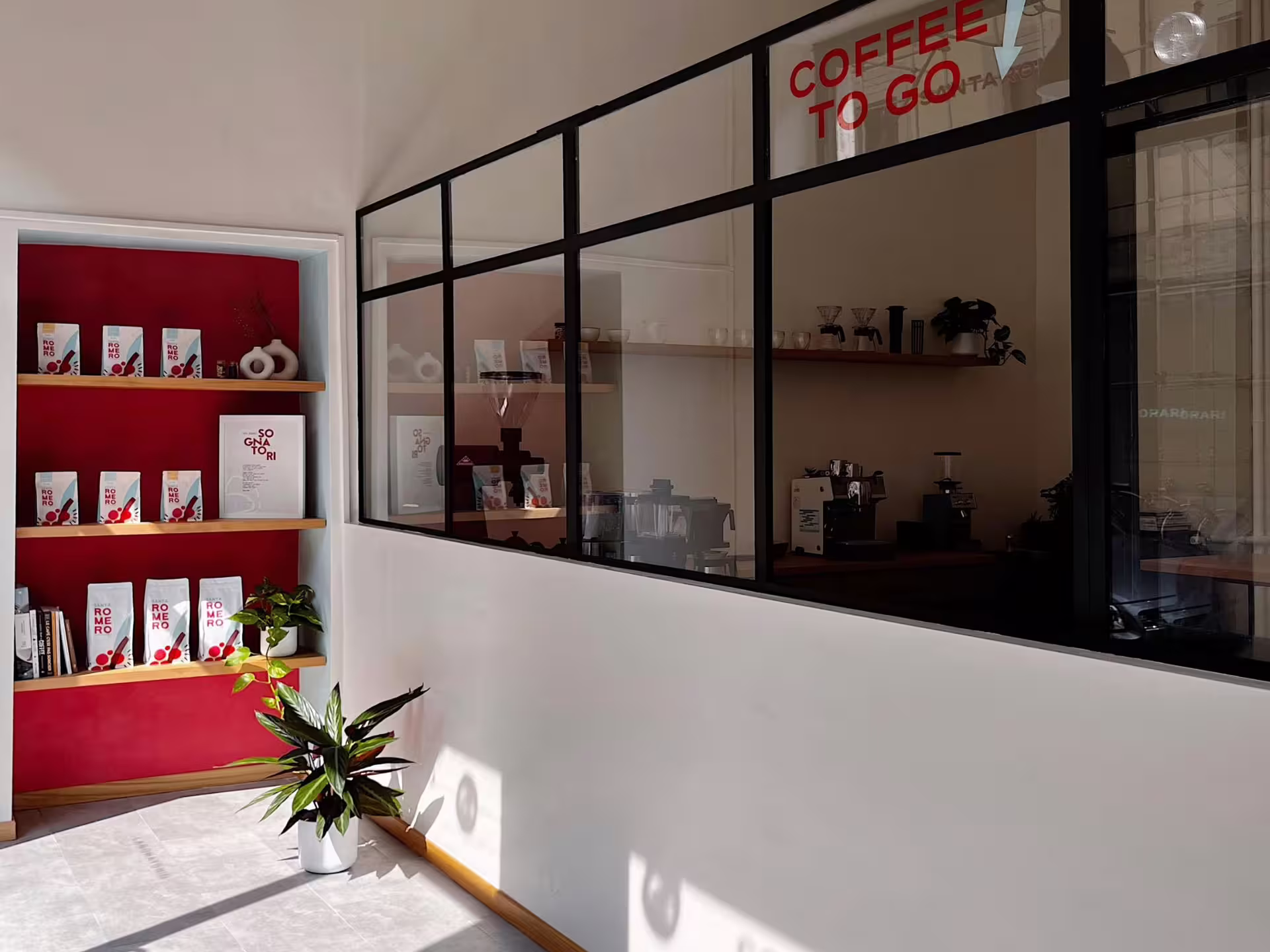Explore a stylish coffee roastery in Turin with shelves of specialty beans and a modern espresso bar setup.