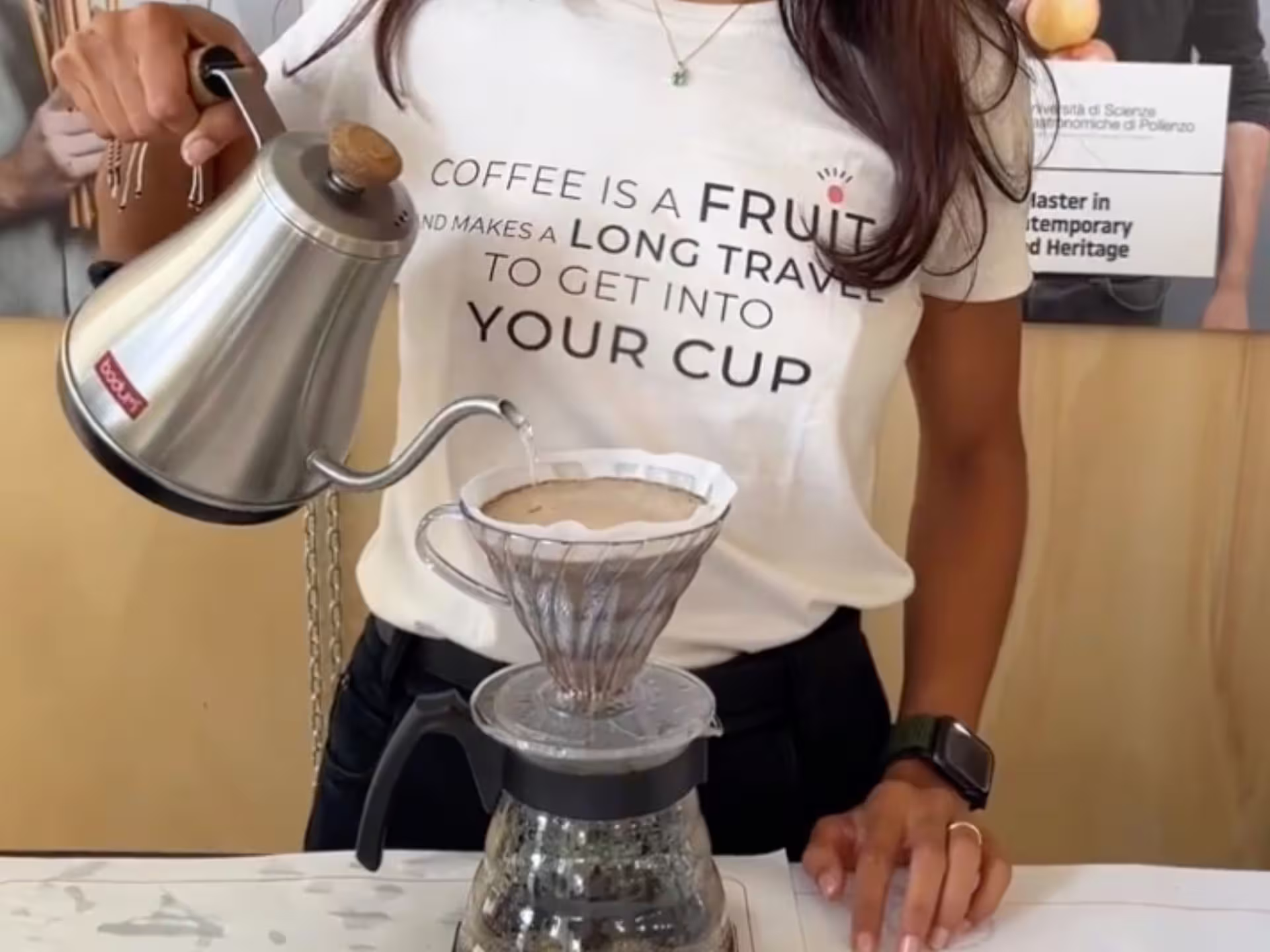 Barista pours hot water over coffee grounds in a specialty coffee tasting experience in Turin.