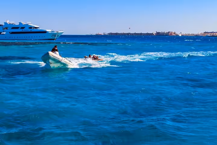 Speedboat towing a banana boat in El Gouna lagoon, Red Sea, on a snorkeling and dolphin tour with lunch