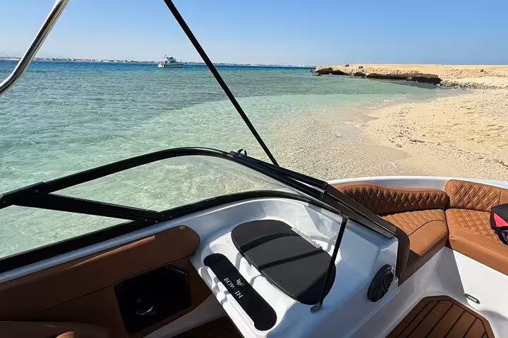 Speedboat anchored in crystal-clear Red Sea at Magawish Island, private Hurghada snorkeling trip