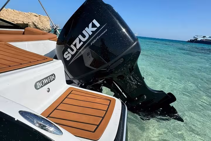 Speedboat outboard motor in crystal-clear Red Sea water at Hula Hula Island, Hurghada snorkeling trip