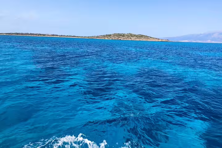 Vibrant blue waters near a scenic island, perfect for a half-day speedboat tour with snorkeling opportunities.