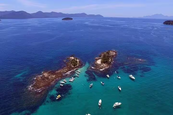 Aerial view of speedboats near rocky islets in crystal-clear waters on a full-day tour in Angra and Islands from Rio.