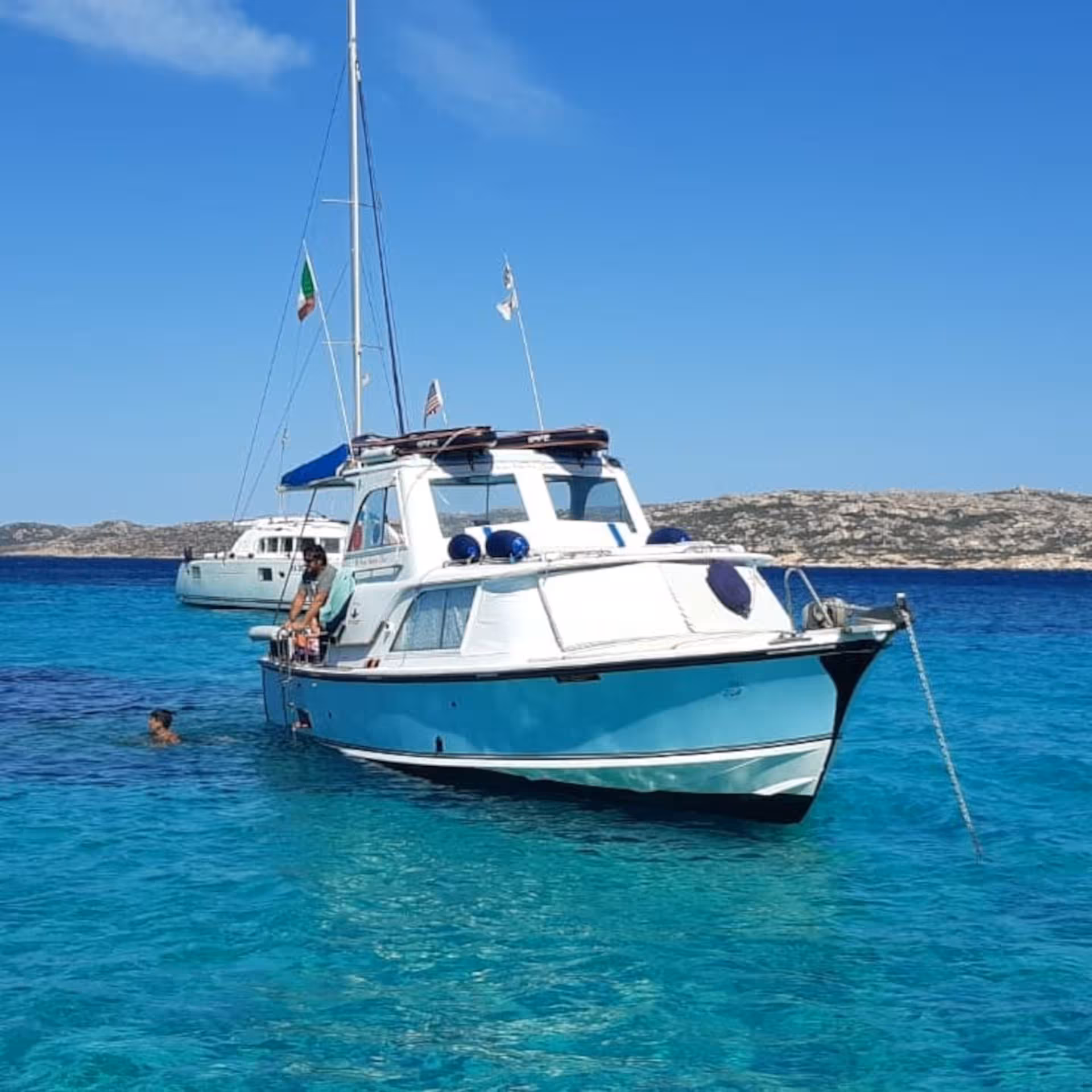 Speedboat anchored in the crystal-clear waters of La Maddalena Archipelago, perfect for a scenic Palau tour.