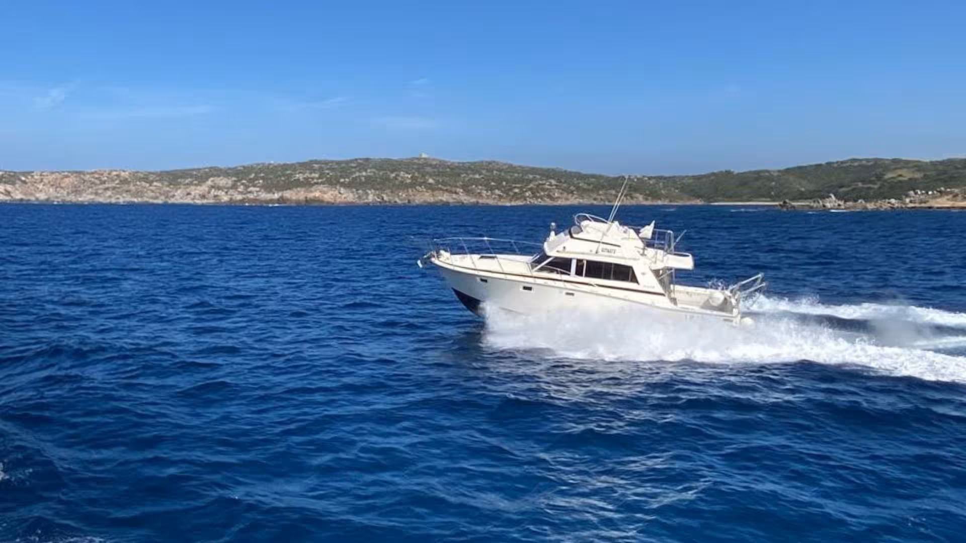 Speedboat navigating vibrant blue waters of La Maddalena Archipelago, ideal for tours from Santa Teresa di Gallura.