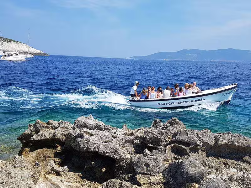 Speedboat with passengers cruising turquoise waters near Vis, Croatia on Vis and Hvar boat tour to Blue Cave