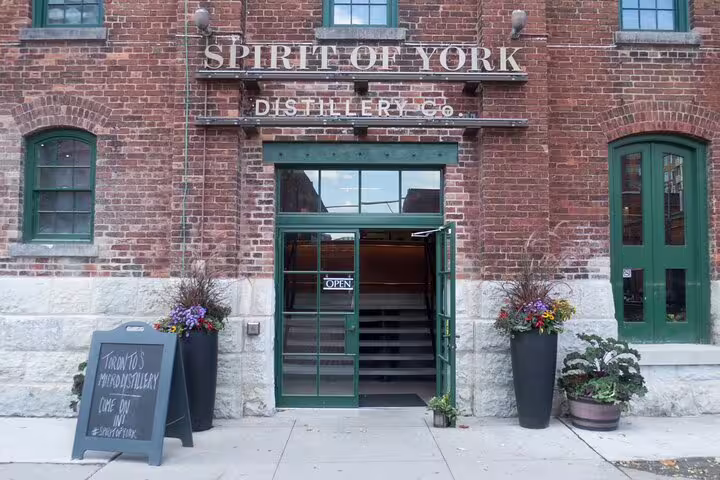 Spirit of York Distillery Co brick building entrance with green doors and open sign in Toronto's Distillery District