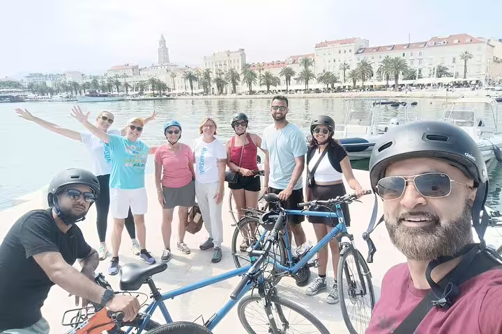 Split City Bike Tour group selfie by Split waterfront and Riva promenade with bikes and helmets
