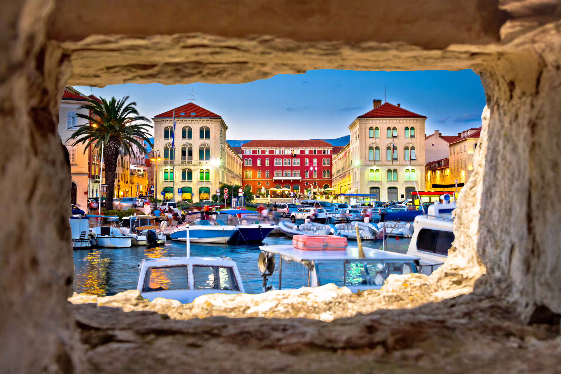 Split Riva waterfront and harbor at dusk, view framed by stone wall on self-guided walking tour audioguide