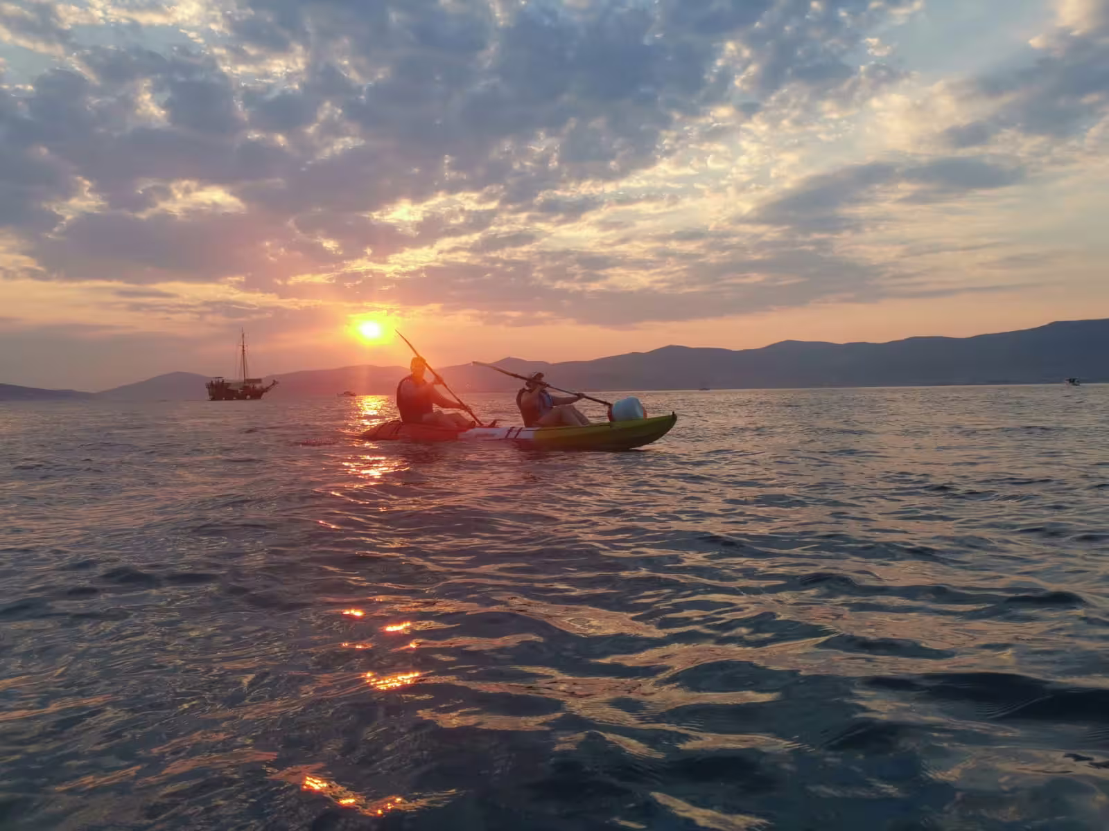 Guided sea kayaking at sunset from Split with wine, paddling the Adriatic as a sailboat passes in the distance