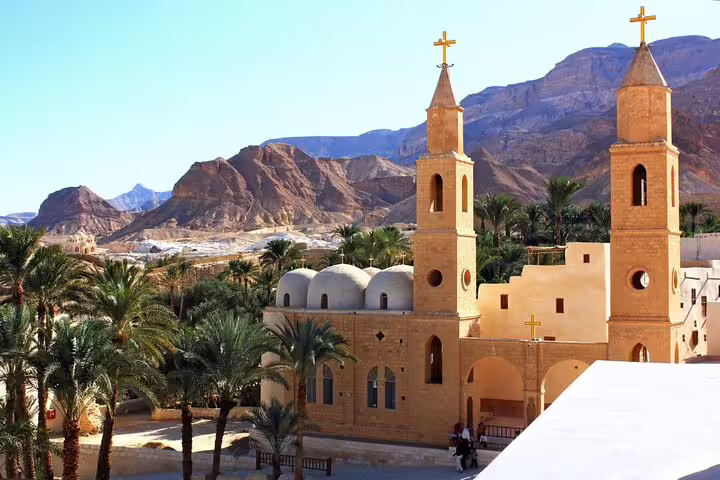 St Antonius Monastery church towers and palm oasis with Red Sea Mountains on a private full-day trip from Cairo