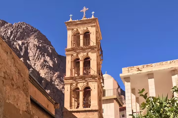 Bell tower of St Catherine Monastery framed by Sinai mountains under blue sky on Cairo overnight Mount Sinai tour