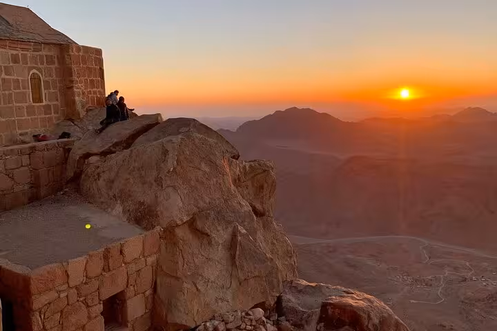 Sunrise over Sinai mountains beside summit chapel on Mount Sinai hike and St Catherine’s Monastery tour from Sharm