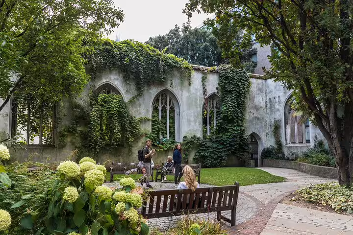 People enjoy a serene moment in the lush garden of St. Dunstan in the East, a hidden gem on a London private tour.