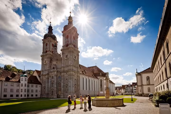 Tourists admire the historic St. Gallen Abbey under a bright blue sky, a highlight of the St. Gallen & Appenzell tour.