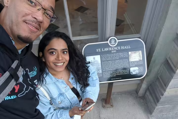 Couple smiling at St. Lawrence Hall 1850 heritage plaque on Toronto Old Town walking tour