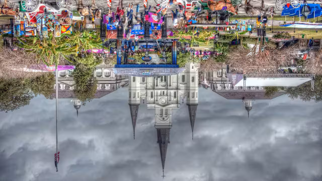 Historic St. Louis Cathedral with a bustling Jackson Square in New Orleans, vibrant event setup and cloudy sky.