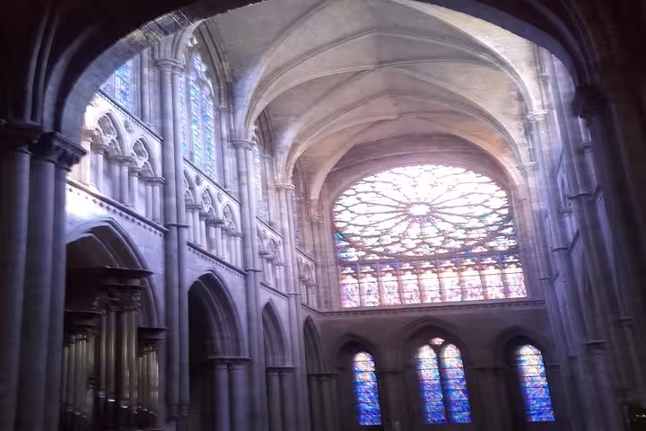 Gothic cathedral interior with rose window stained glass and ribbed vaulted ceiling in St Malo