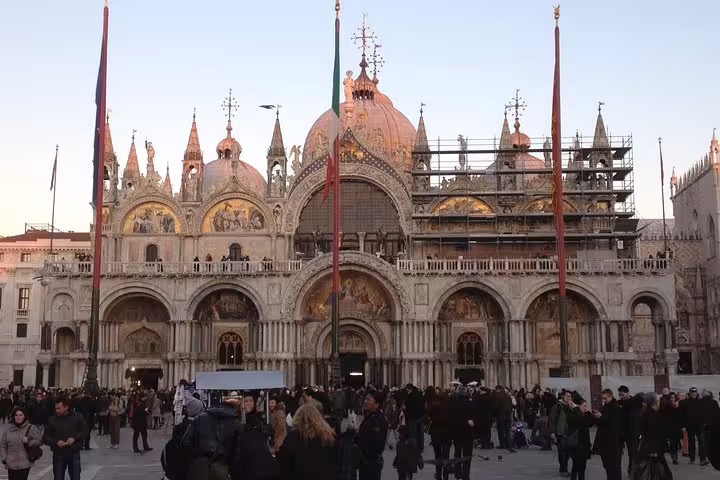 St. Mark's Basilica exterior with domes and crowds, a highlight of skip-the-line guided tours in Venice.