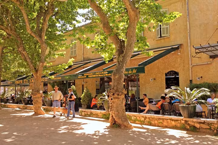 Sunny outdoor café terrace with plane trees in St Paul de Vence, French Riviera