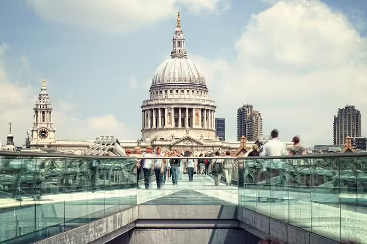 View of St. Paul's Cathedral from Millennium Bridge, London, bustling with tourists, ideal for a skip-the-line Tower of London tour.