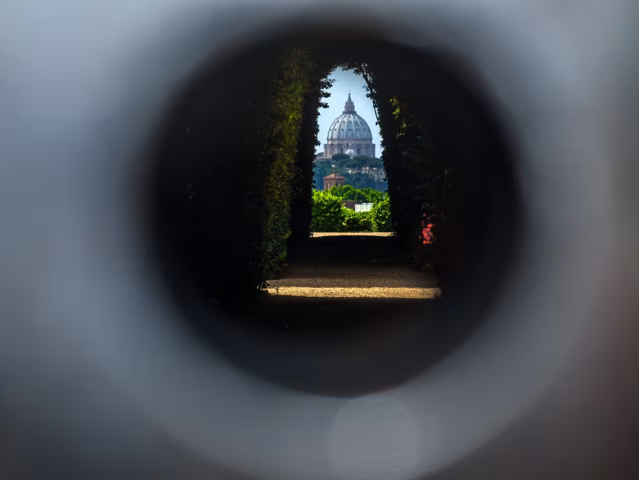 St Peter’s Basilica dome framed by a leafy garden archway, highlight on Truly Rome guided tour