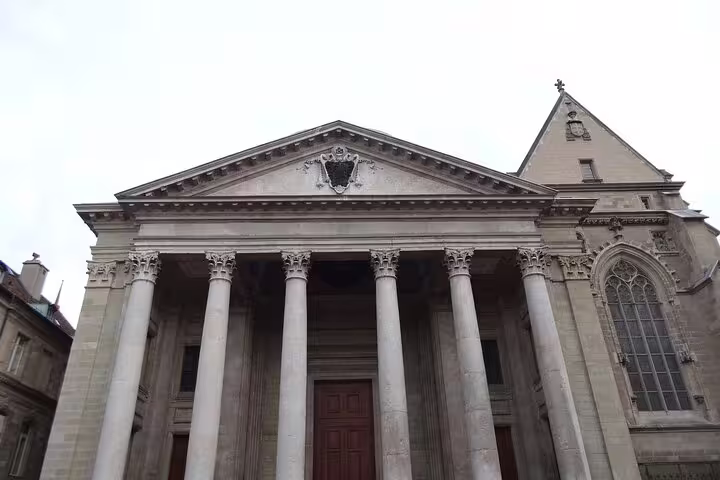 Neoclassical facade of St. Pierre Cathedral in Geneva with tall Corinthian columns and triangular pediment