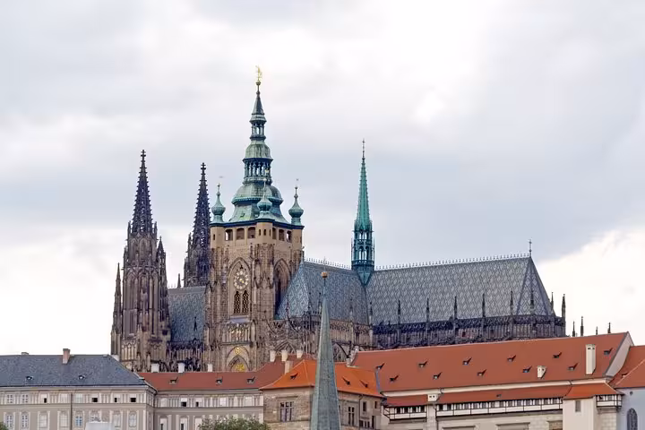St. Vitus Cathedral gothic spires and green copper domes rising above Prague Castle complex
