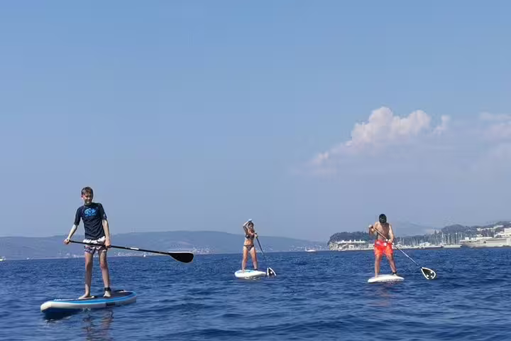 Group stand up paddleboarding on the Adriatic Sea near Split, Croatia, guided SUP tour with coastal views