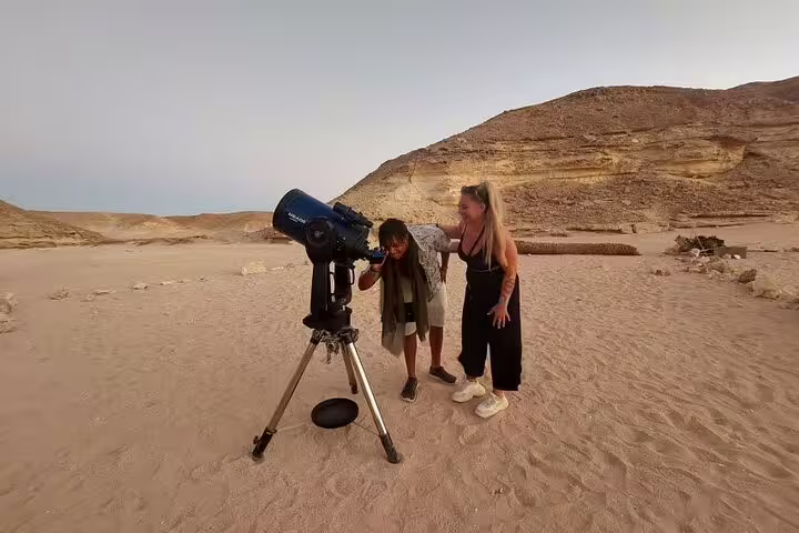 Guests using telescope for stargazing in Sinai Desert from Sharm El Sheikh, after ATV quad bike and Bedouin dinner show