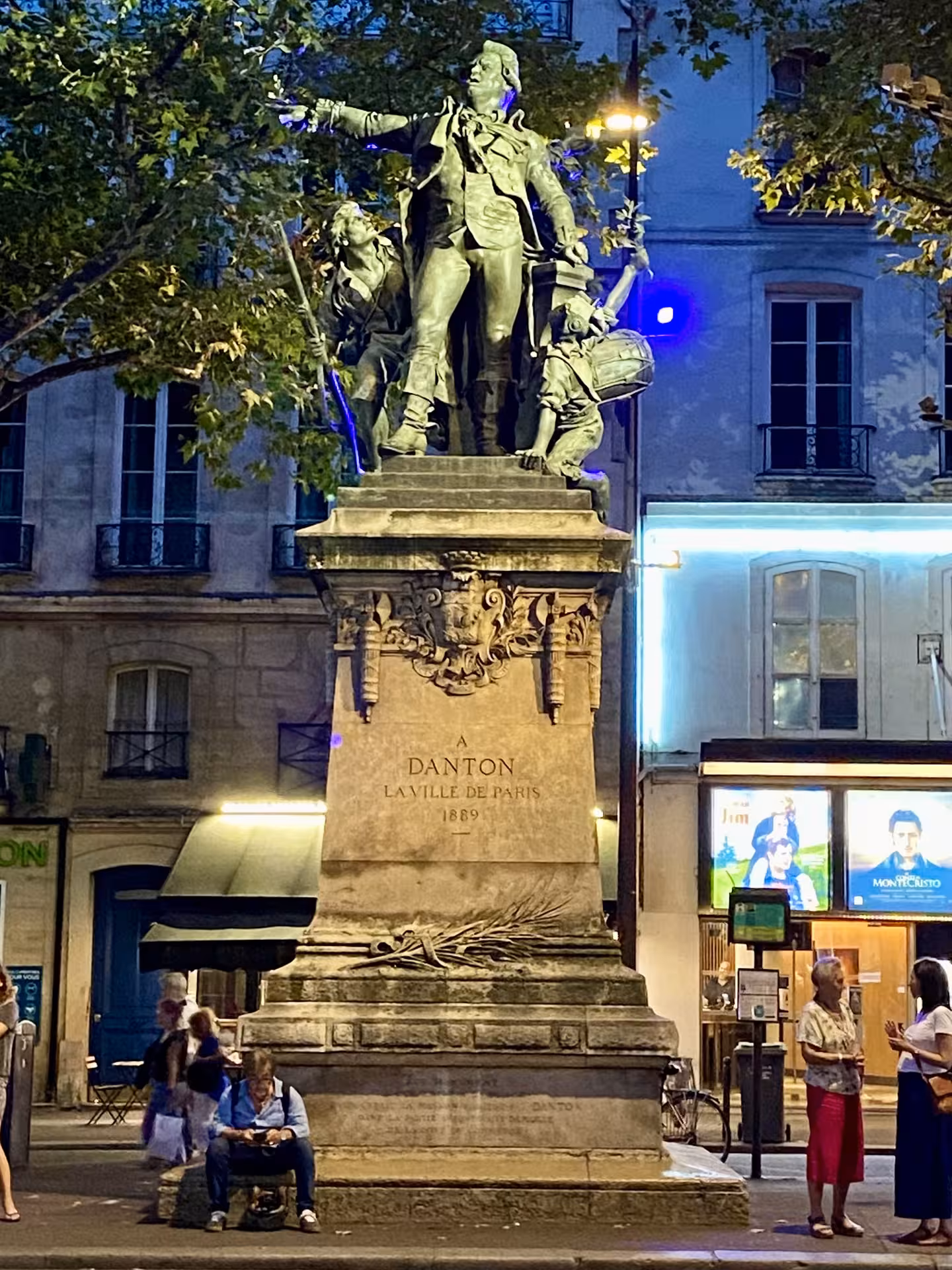 Statue of Danton in Paris illuminated at night, highlighting French Revolution history on a guided tour.