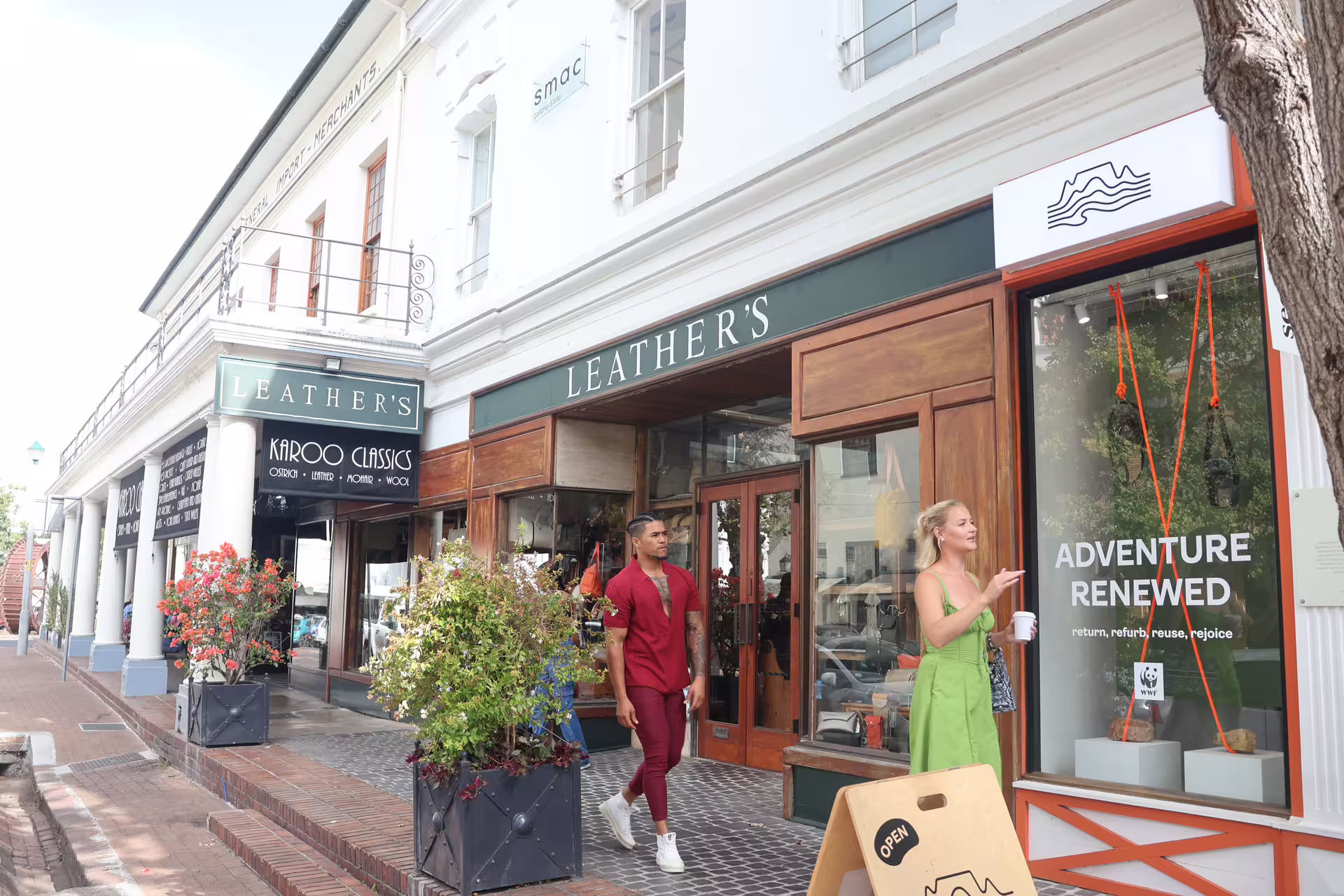 Charming street view in Stellenbosch with visitors exploring local shops on the Franschhoek wine tram tour.