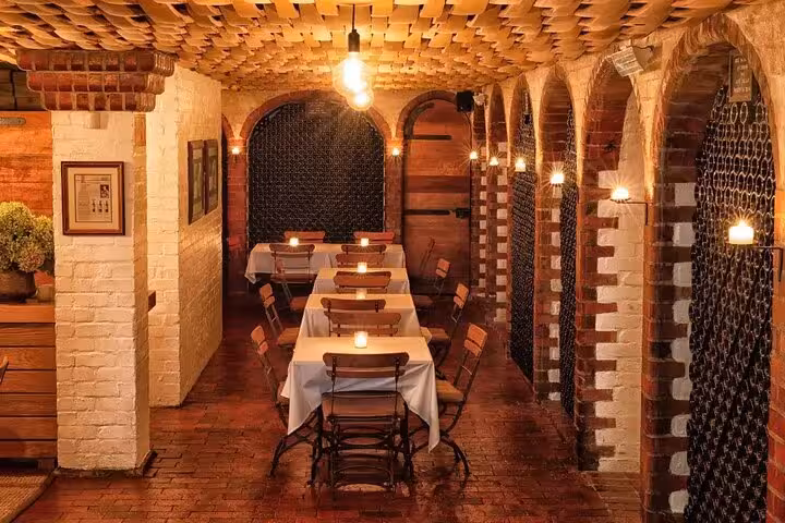 Cozy, candle-lit wine cellar dining area at Rust en Vrede, perfect for intimate Stellenbosch wine experiences.