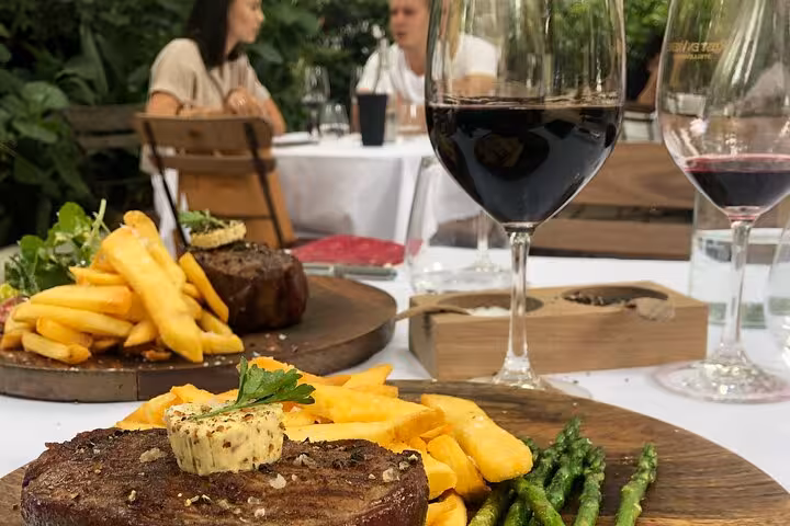 Savor gourmet steak and fries paired with red wine at a scenic Stellenbosch vineyard restaurant during a private tour.