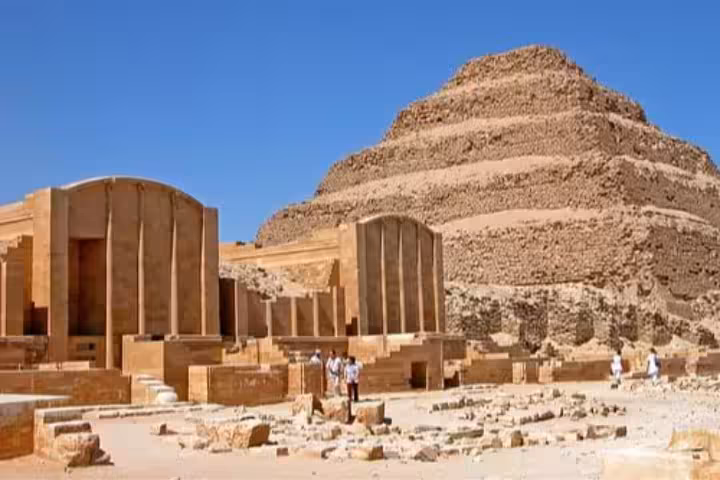 Step Pyramid of Djoser at Saqqara with ancient temple ruins and tourists in Egypt