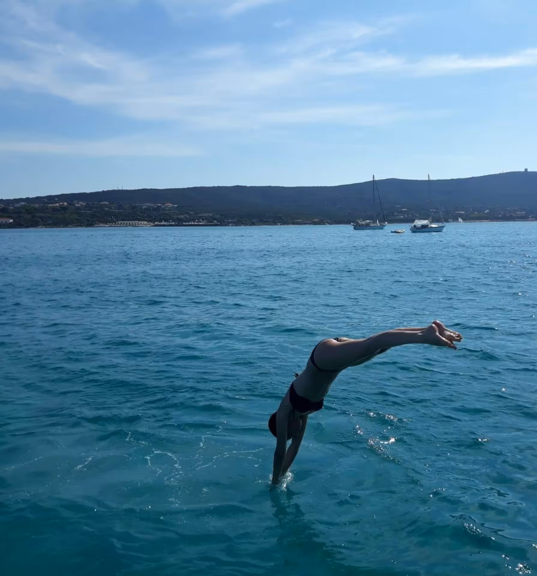 Person diving into the sea from a boat near Asinara Island, showcasing adventure during Stintino excursions.