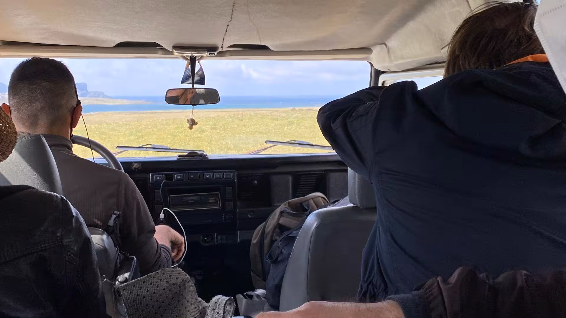 Inside view of a minivan during an Asinara tour, capturing passengers admiring the island's breathtaking scenery.