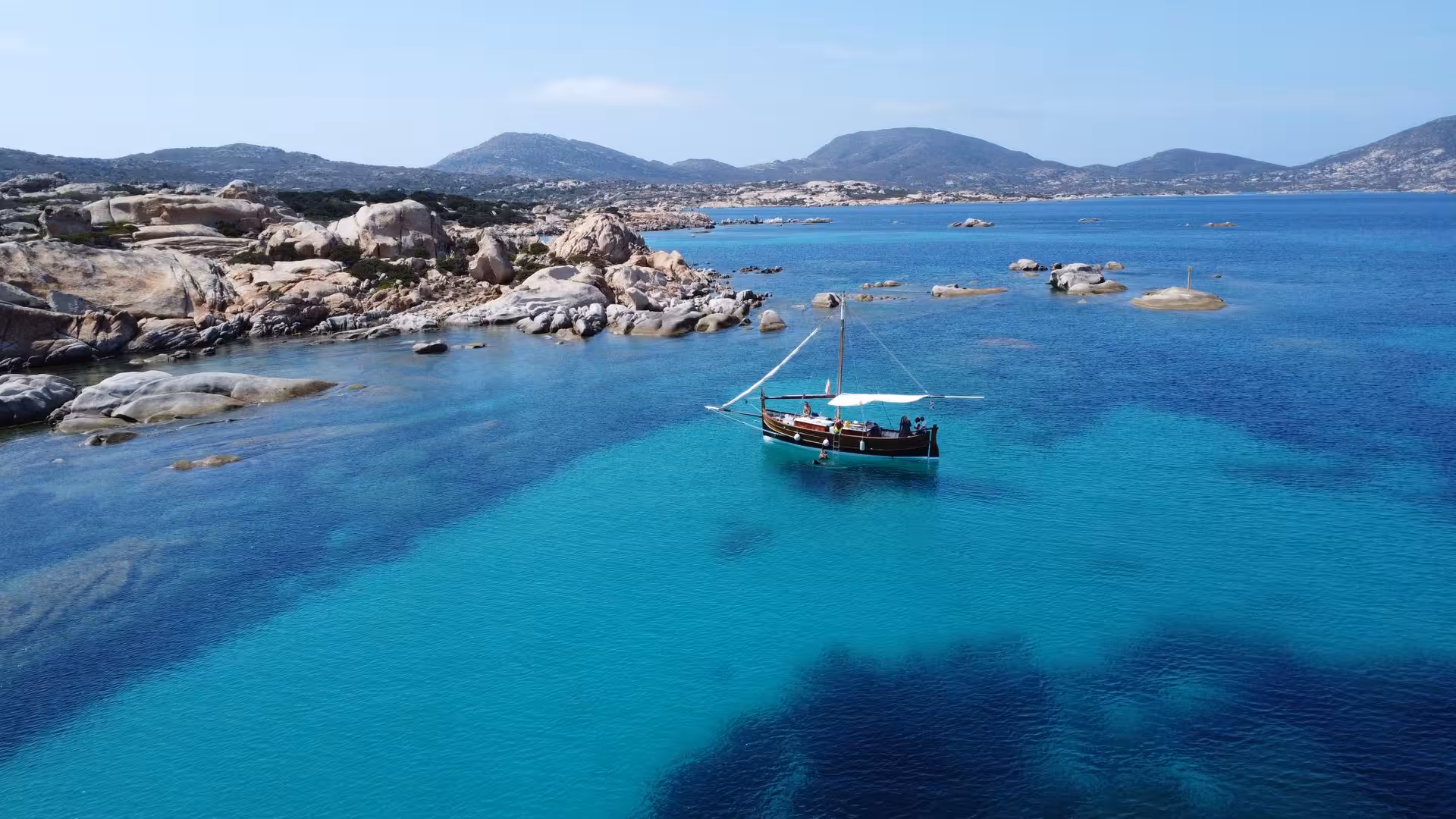 Sailboat anchored in the serene blue waters of Asinara, offering stunning views on a Stintino sailing tour.