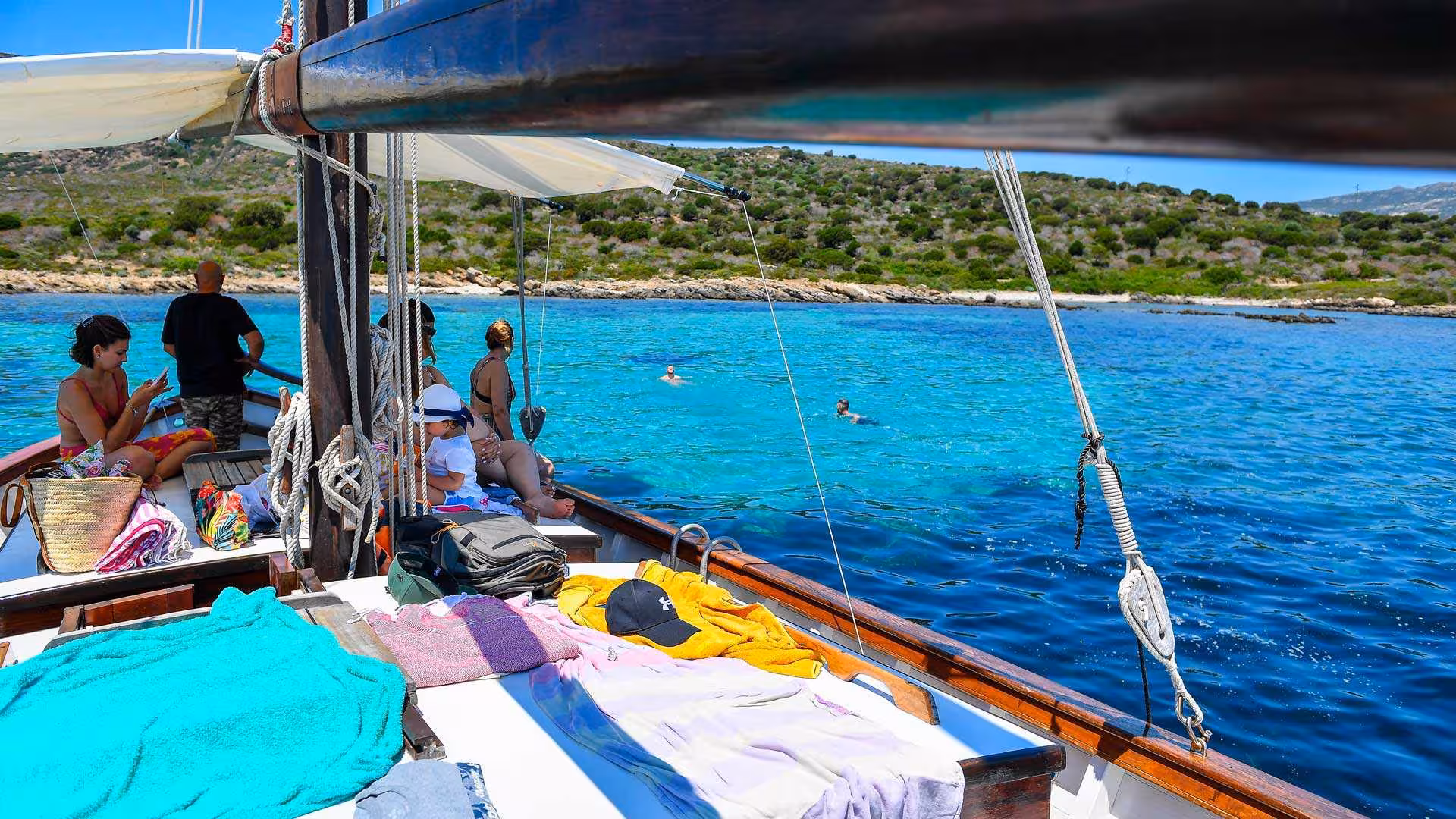 Relaxing on a sailboat with turquoise waters around Asinara, perfect for a day of sunbathing and swimming.
