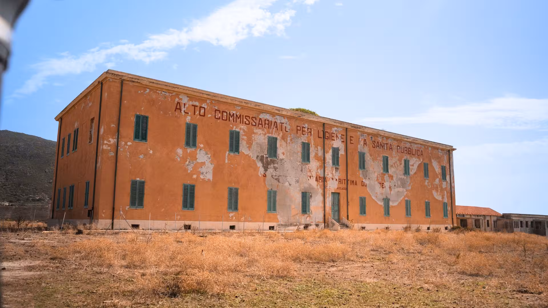 Historic building with faded facade on Asinara Island, a highlight of the Stintino minivan tour.