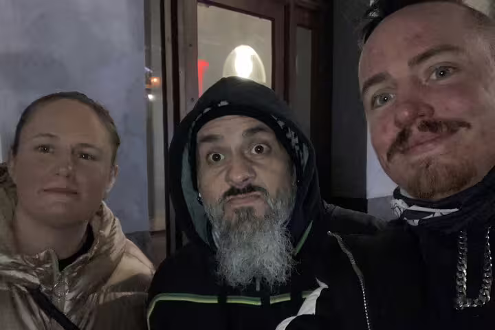 Three people posing for a selfie at night during a Stockholm ghost tour walking hunt