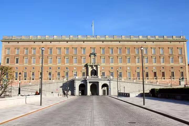 Stockholm Royal Palace facade with arched entrance gate and cobblestone plaza on a clear day