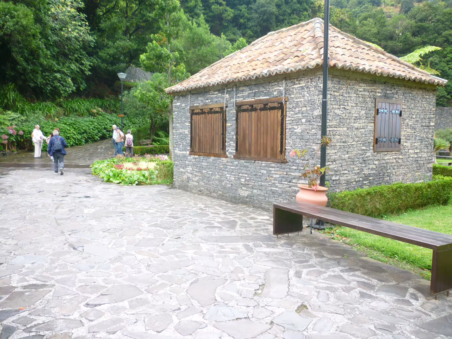 Charming stone house with a rustic roof set in a lush garden, a highlight of the two-day island tour.