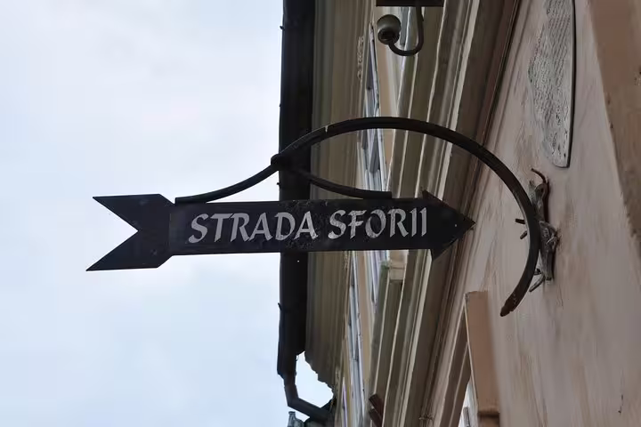 Black iron arrow street sign for Strada Sforii in Brasov Old Town
