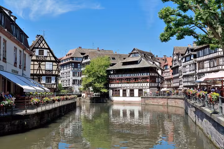 Half-timbered buildings along the canal in Strasbourg's Petite France district on a sunny day