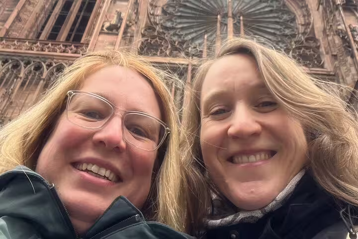 Two women selfie in front of Strasbourg Cathedral façade on a Strasbourg scavenger hunt city highlights tour