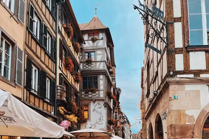 Half-timbered buildings with flower boxes lining a charming old town street in Strasbourg, Alsace